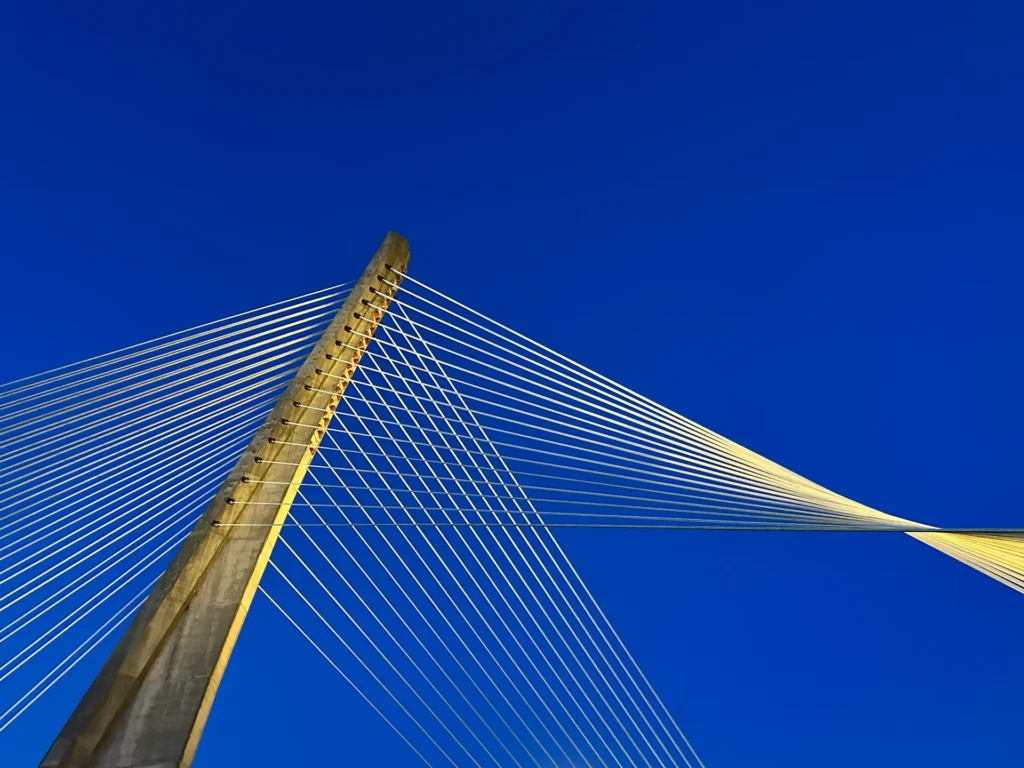 Cable-stayed bridge with yellow cables against a blue sky.