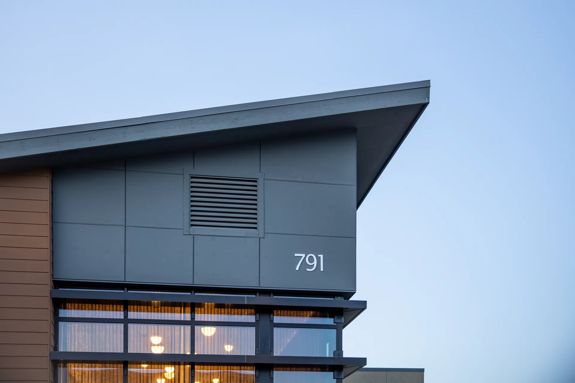 Gray cladding, glazing and an angled roof at a contemporary building.